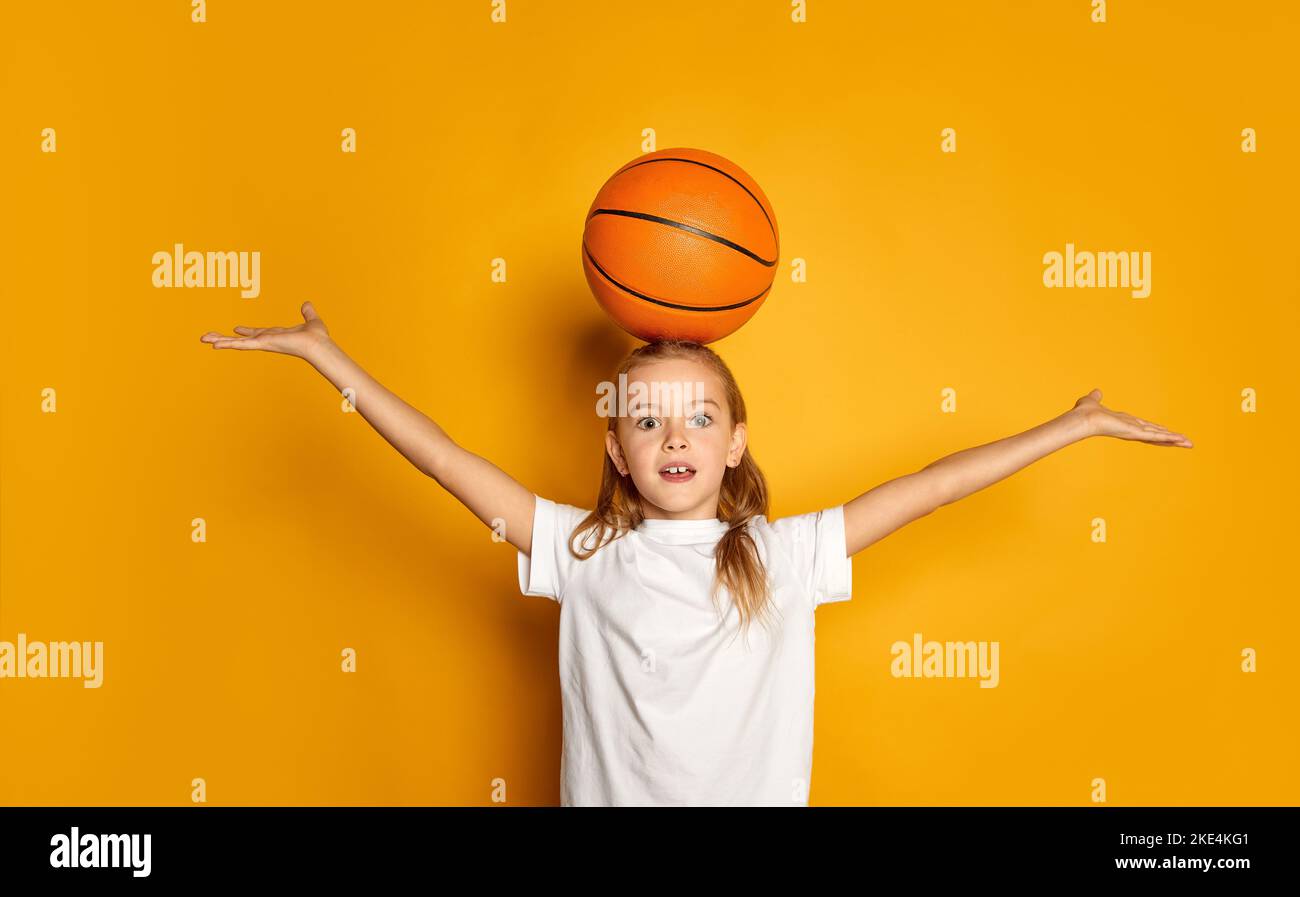 A little boy in panama, a yellow jersey, red shorts and white sneakers sits  on a yellow penny and holds a basketball multicolored ball, a soccer black  Stock Photo - Alamy
