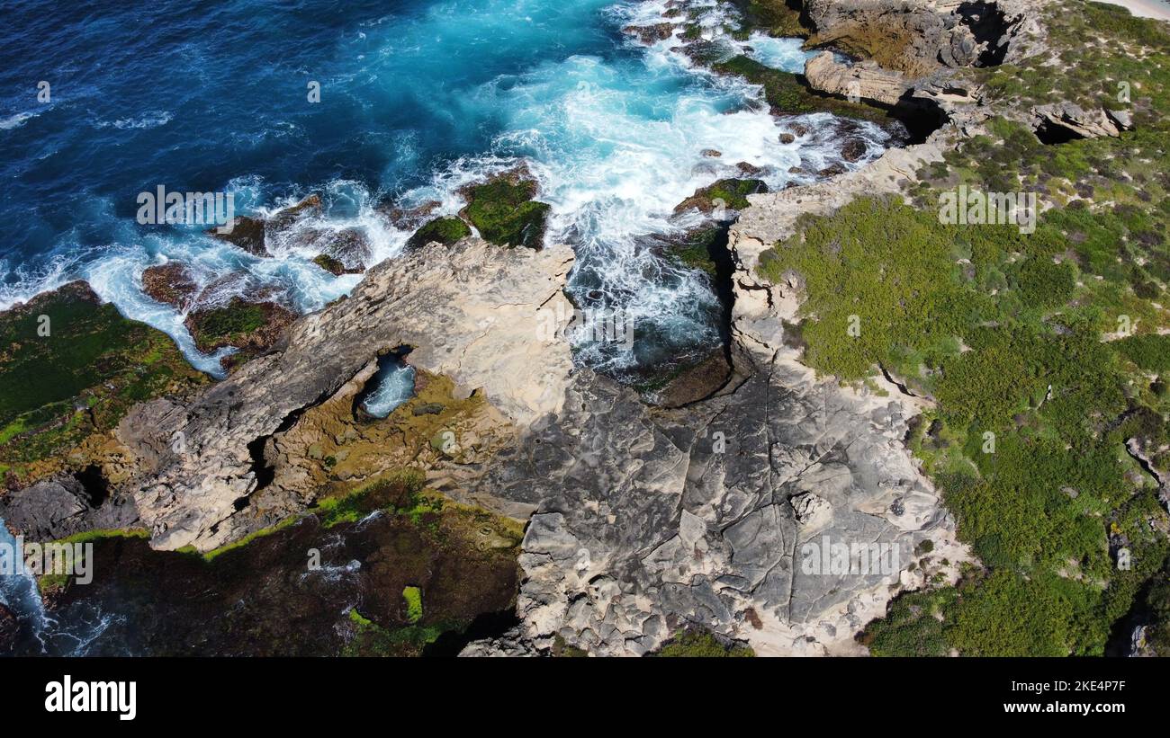 An aerial view of a scenic rocky coastline against the azure sea in ...
