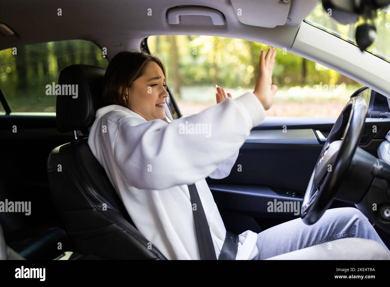 Young woman with fear in eyes driving car hands not on steering wheel Stock Photo Alamy