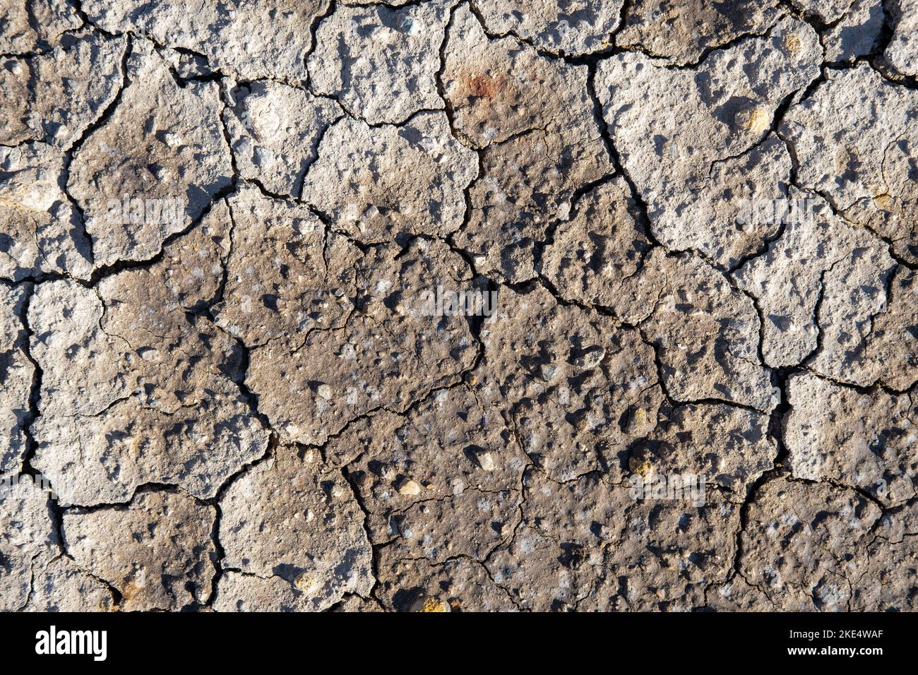 Dry soil in the cracks, natural background, hot climate. Drought land without water texture. The concept of global warming, cataclysms and drought. Stock Photo