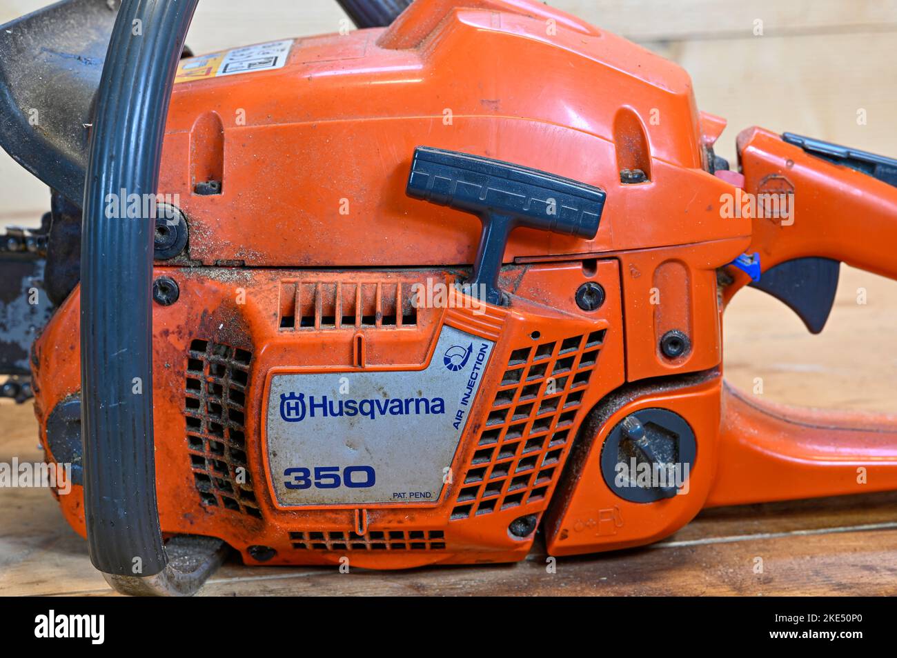 Orange chainsaw Husqvarna 350 standing on wooden workbench Stock Photo