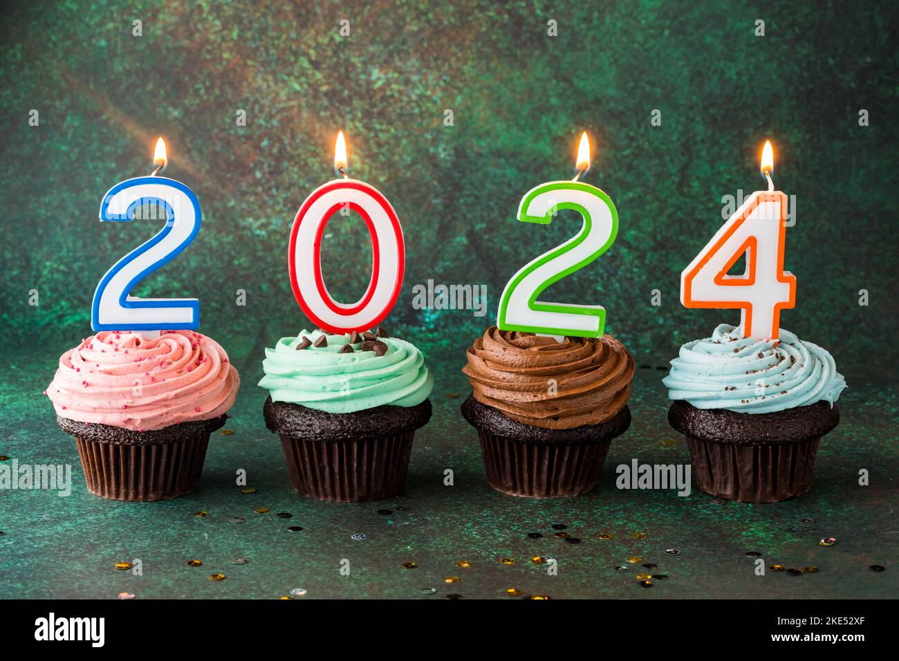Buttercream frosted cupcakes with number candles for the New Year 2024. Stock Photo