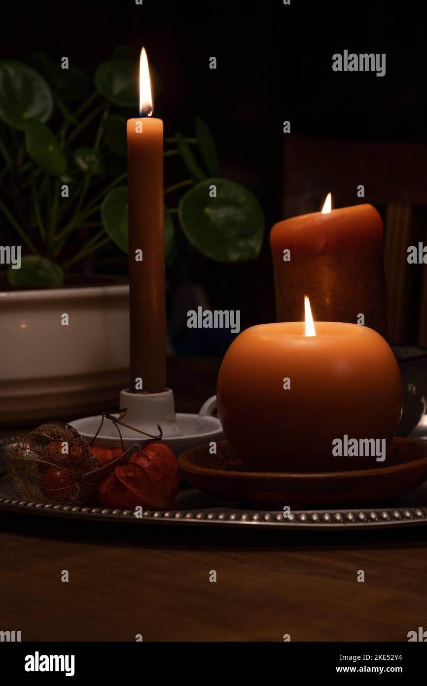 A vertical shot of candles with different shapes placed on a table Stock Photo