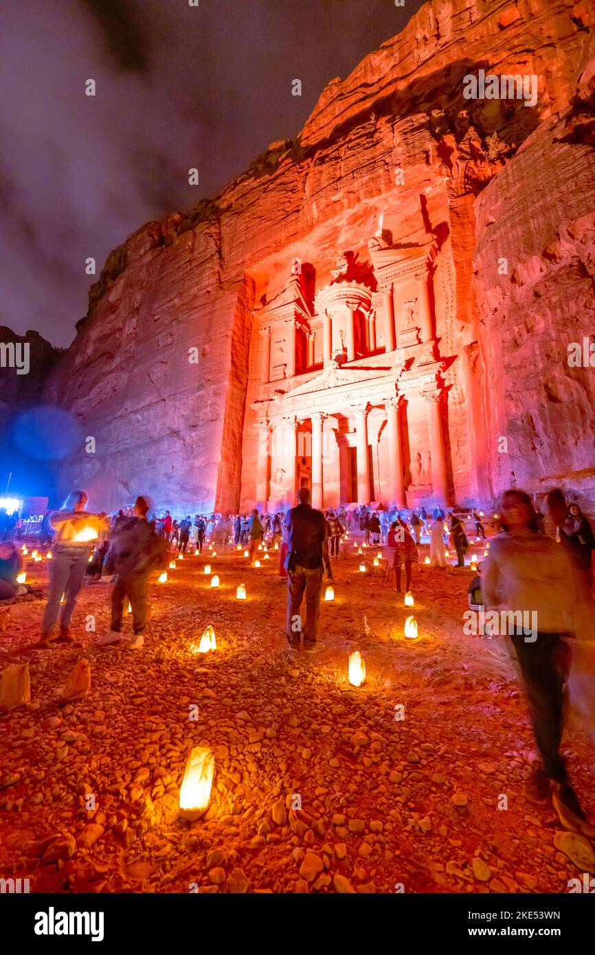 Tourists sitting in front of the Treasury in Petra Jordan illuminated by candles at night Stock Photo