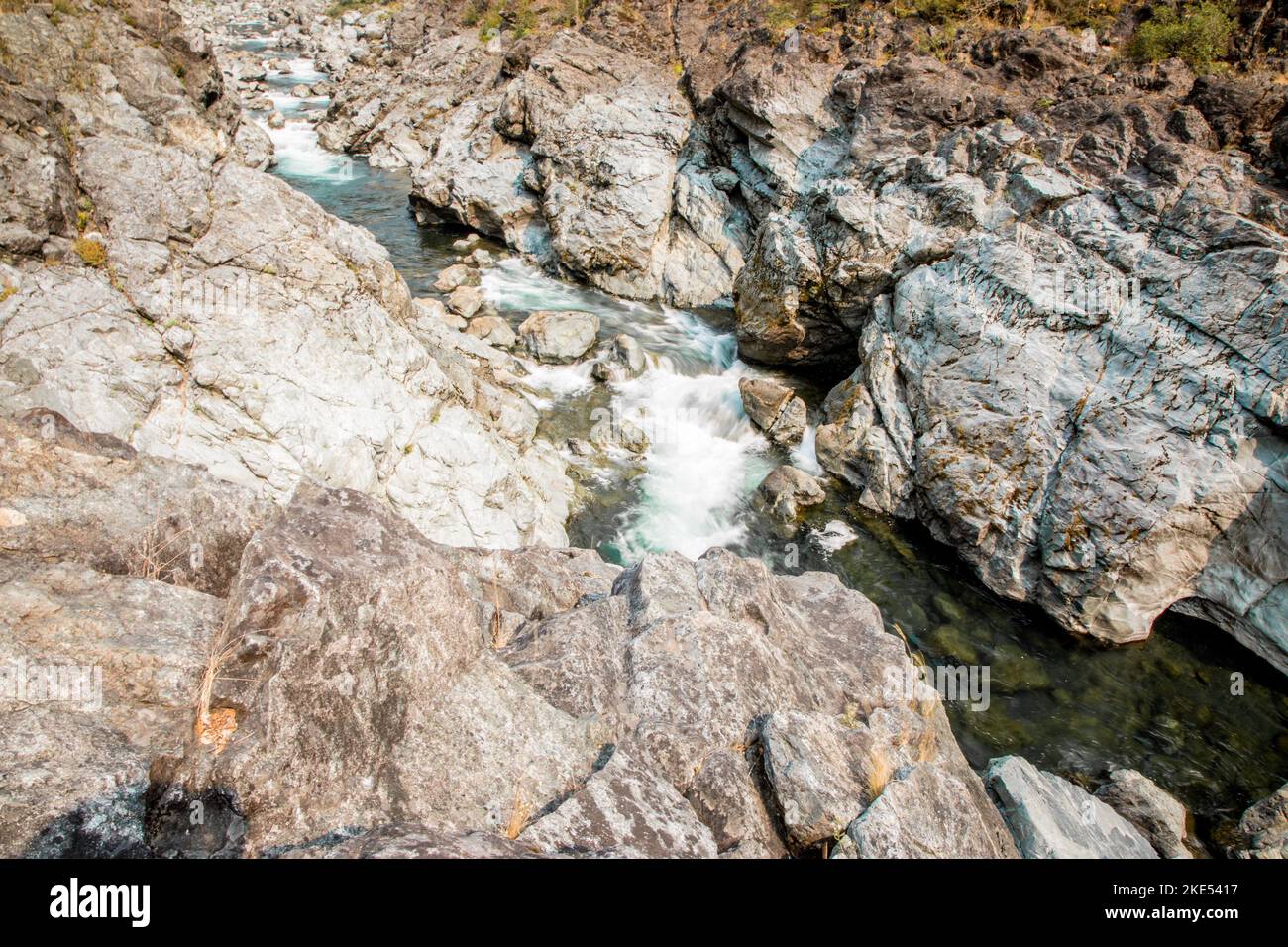 A narrow rocky river flowing downstream on a sunny day Stock Photo - Alamy
