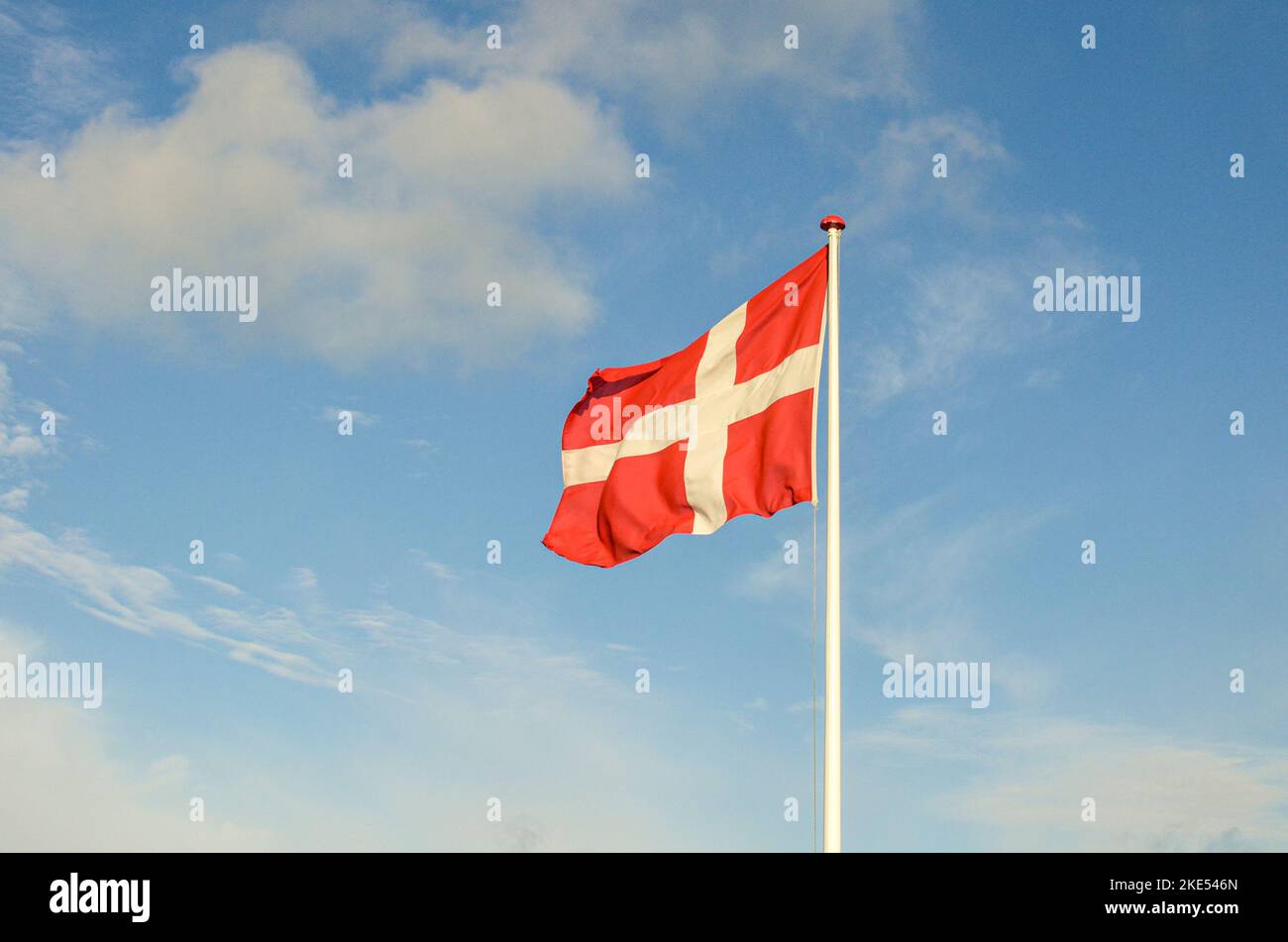 Danish flag with blue sky and light clouds Stock Photo