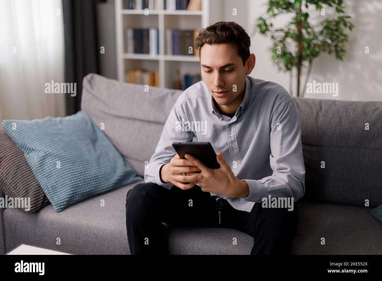 Man with tablet on couch Stock Photo