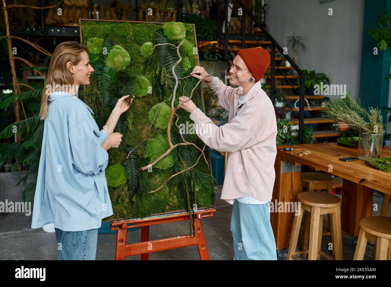 Two designers working on floral collage at florist shop Stock Photo