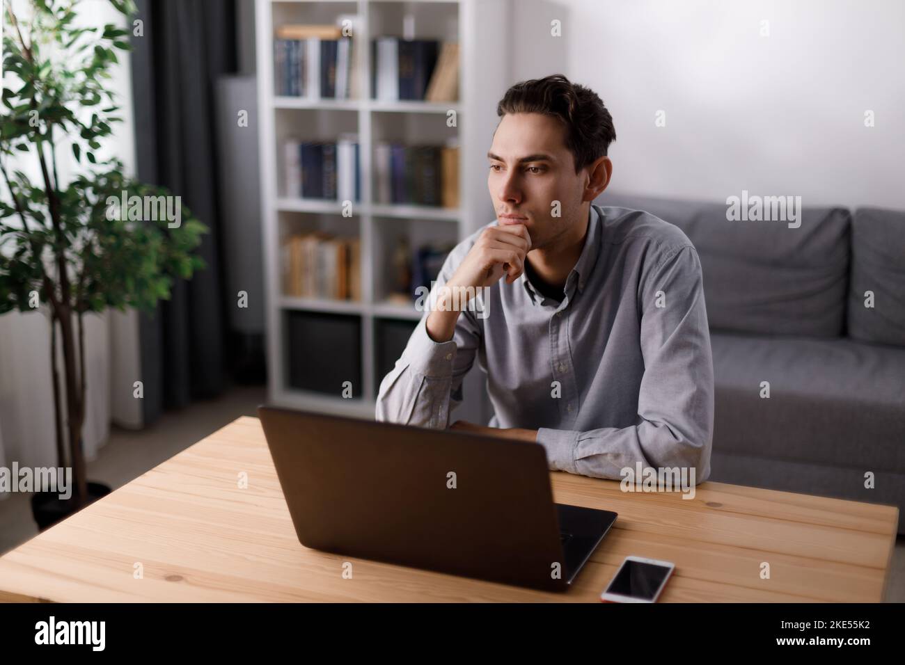 Thoughtful man with laptop Stock Photo