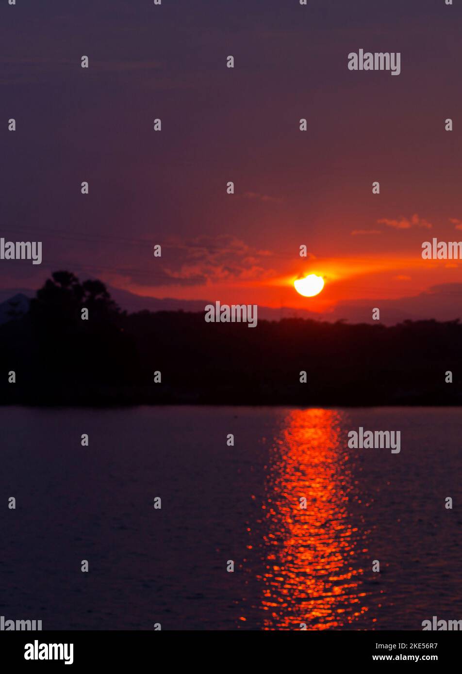 The sun was about to set in red. In front of the lake was a lake of ...