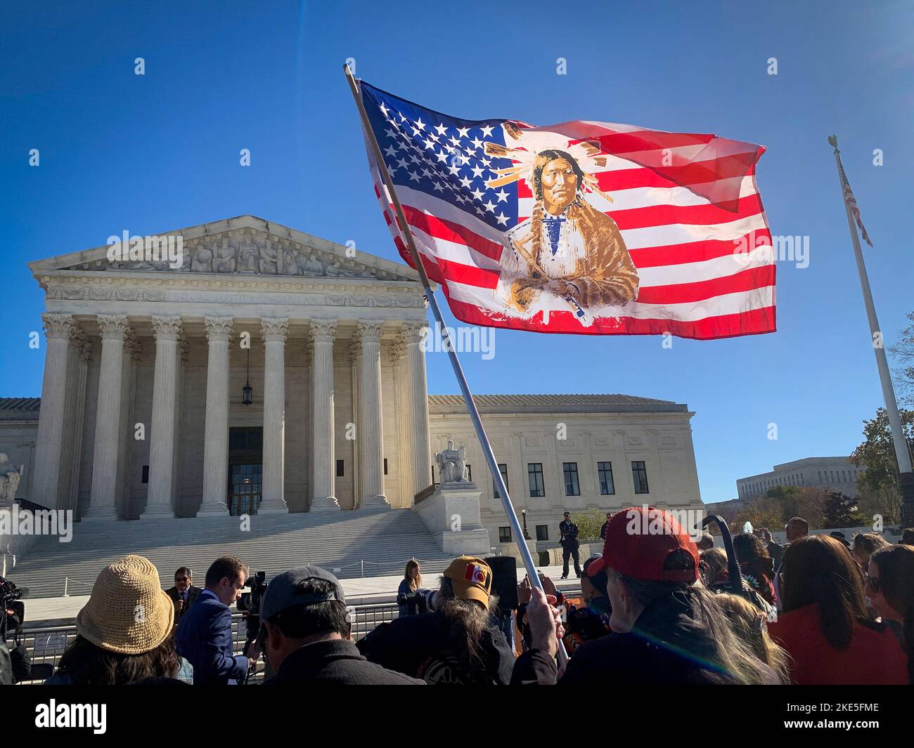 November 9, 2022, Washington, District of Columbia, USA: As the U.S. Supreme Court hears opening arguments on the constitutionality of the Indian Child Welfare Act (ICWA), a 1978 federal law which protects the interests of both Indian children and tribes, a U.S. flag with a Native image is held at a rally in front of the Supreme Court. (Credit Image: © Sue Dorfman/ZUMA Press Wire) Stock Photo