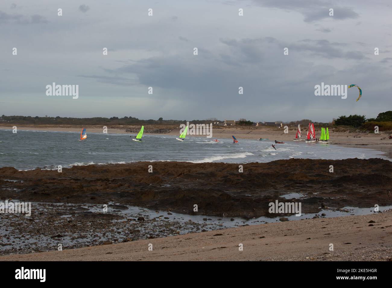 Coastal scene with boats and kite surfing, very windy, bad weather. The