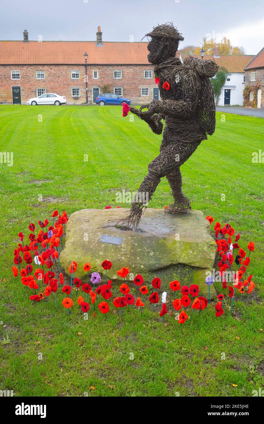 An Osier or willow sculpture of a First World War Soldier in remembrance of the people from Great Ayton who died in combat decorated with poppies Stock Photo