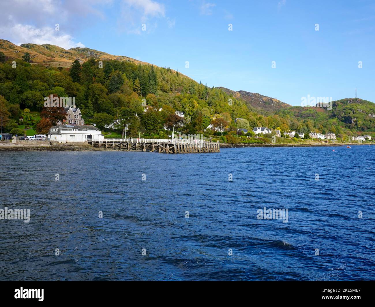People fishing from a pier and homes of Tignabruaich, Kyles of Bute, on the Cowal Peninsula, Scotland, UK. Stock Photo
