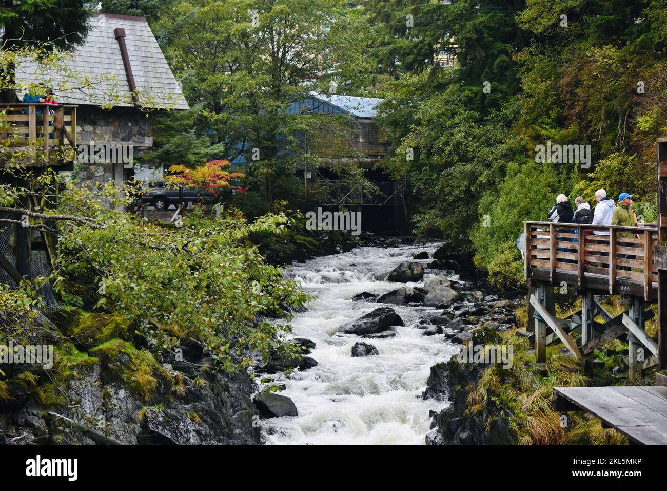 A group of people looking at the raging river from the bridge Stock ...