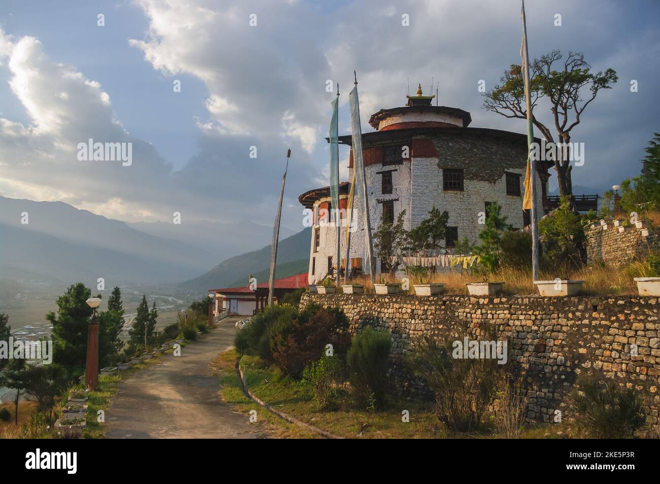 Beautiful sunset landscape view of landmark ancient traditional watchtower Ta Dzong overlooking Paro valley in Western Bhutan Stock Photo