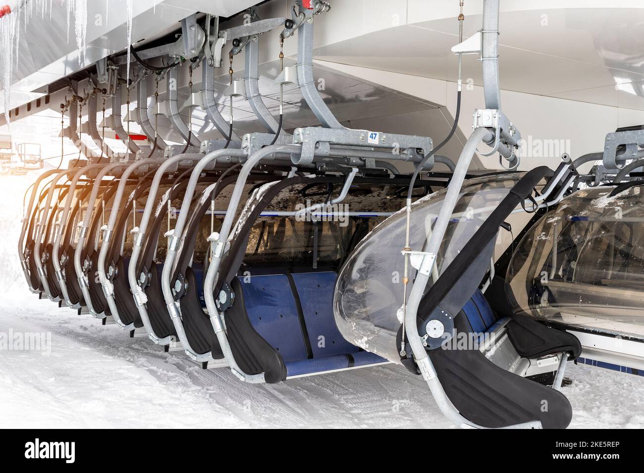 Many ski lift empty ropeway seats on cable way station on hilghland alpine mountain winter