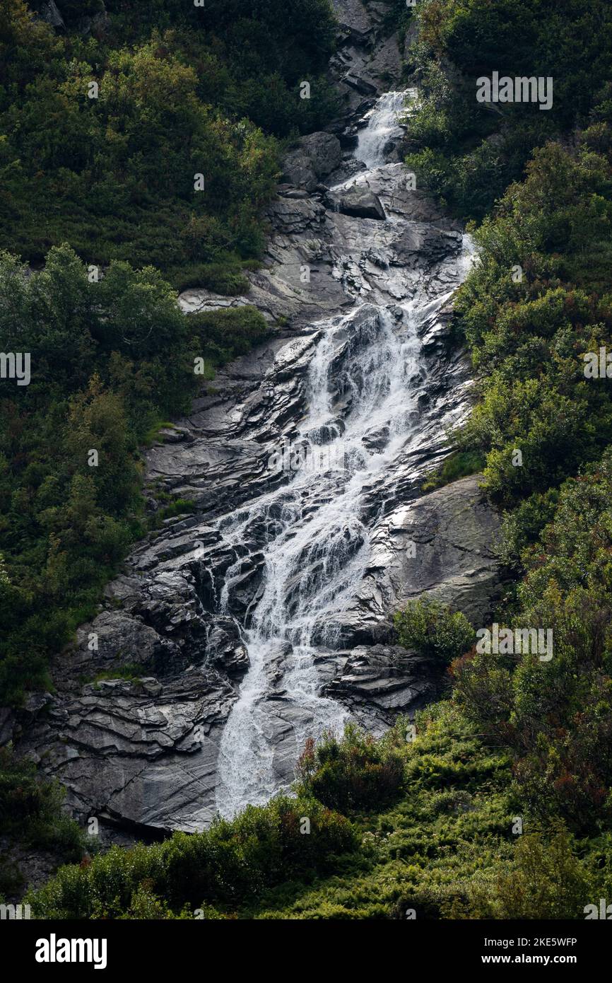 A vertical shot of a rocky waterfall in the woods Stock Photo - Alamy