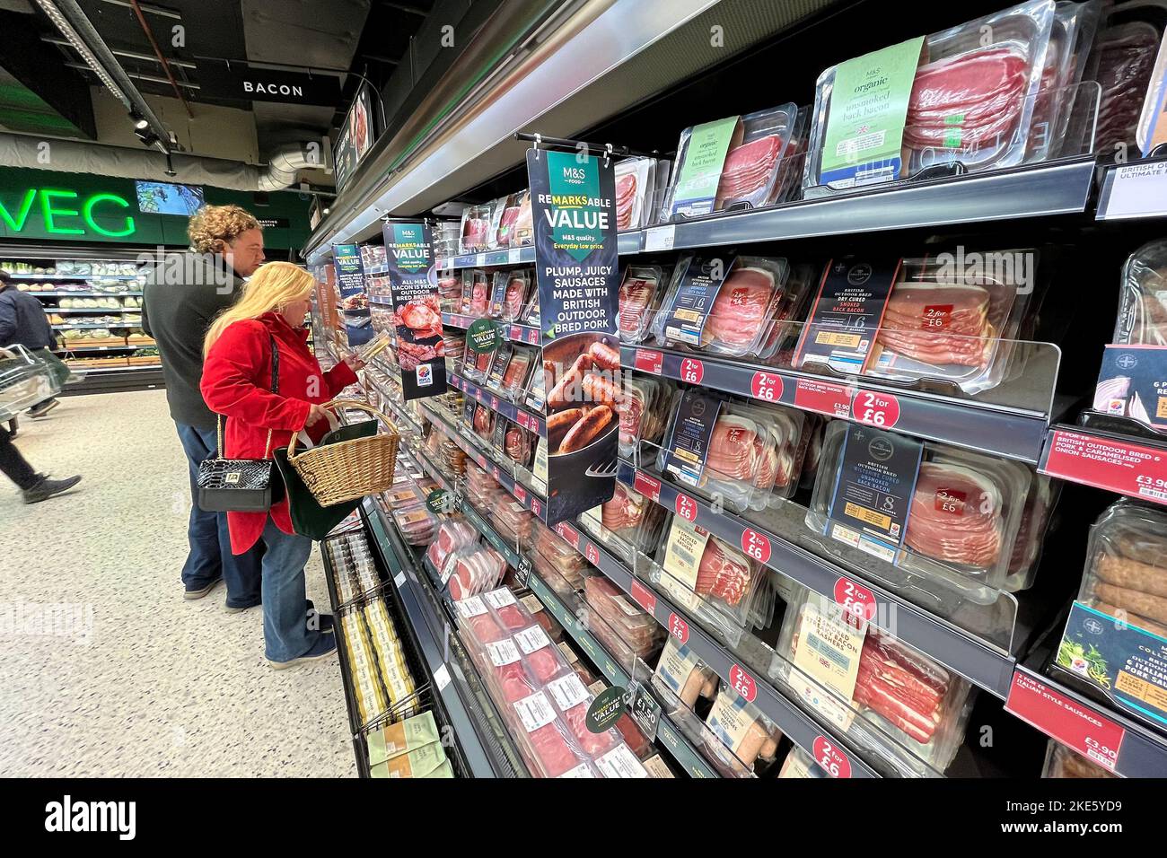 Customers look at packaged meat products at m and s food hall at