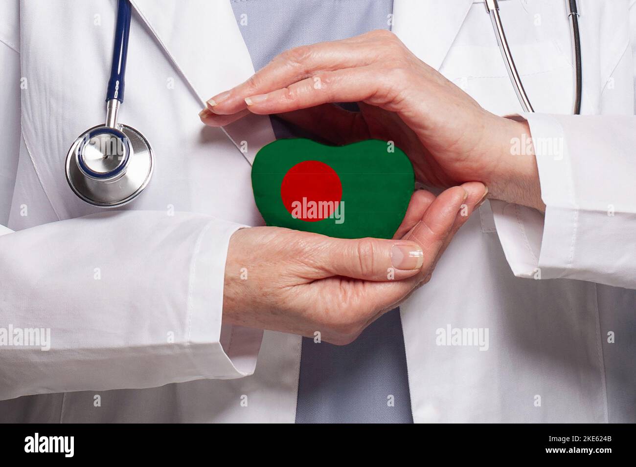 Bangladesh doctor holding heart with flag of Bangladesh background. Healthcare, charity