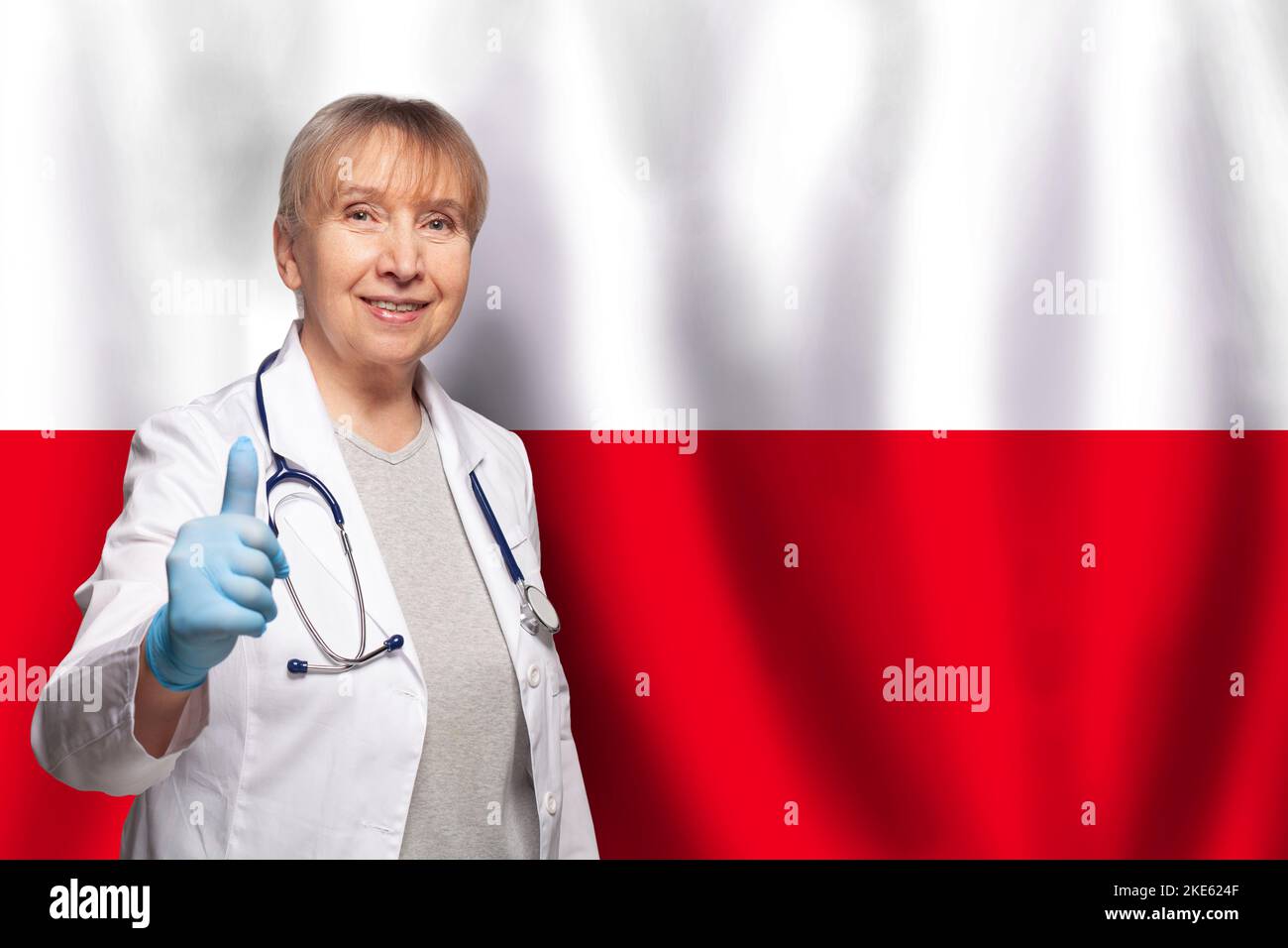 Polish smiling mature doctor woman holding stethoscope on flag of