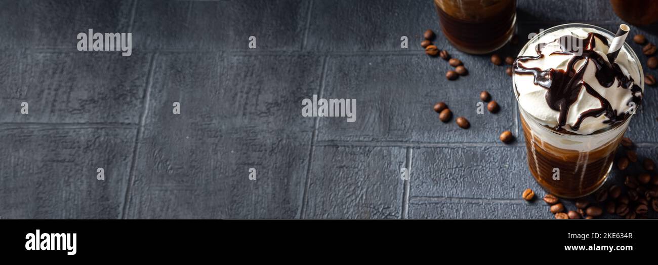 pour the frappe from the shaker into a tall glass , beautiful and clean  composition with coffee beans and amaretti biscuits Stock Photo - Alamy