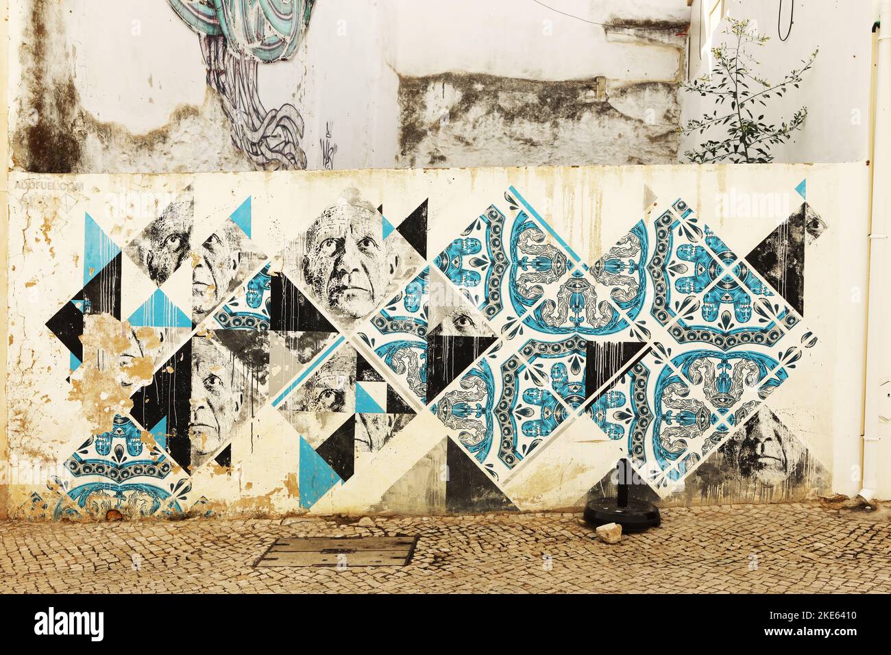 A mural of male faces and blue tiles on a wall in old town, Lagos, Algarve, Portugal Stock Photo
