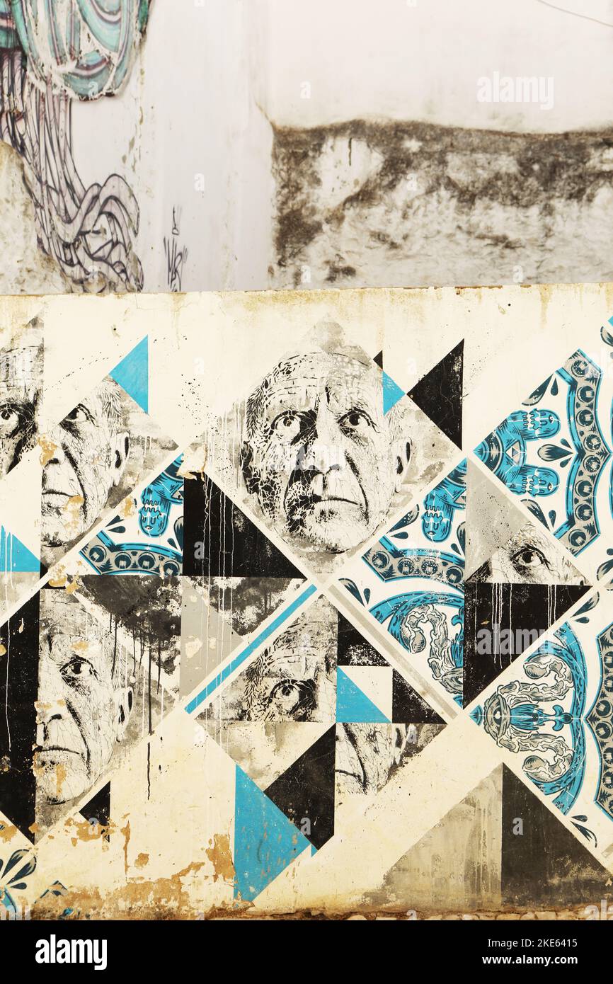 A mural of male faces and blue tiles on a wall in old town, Lagos, Algarve, Portugal Stock Photo