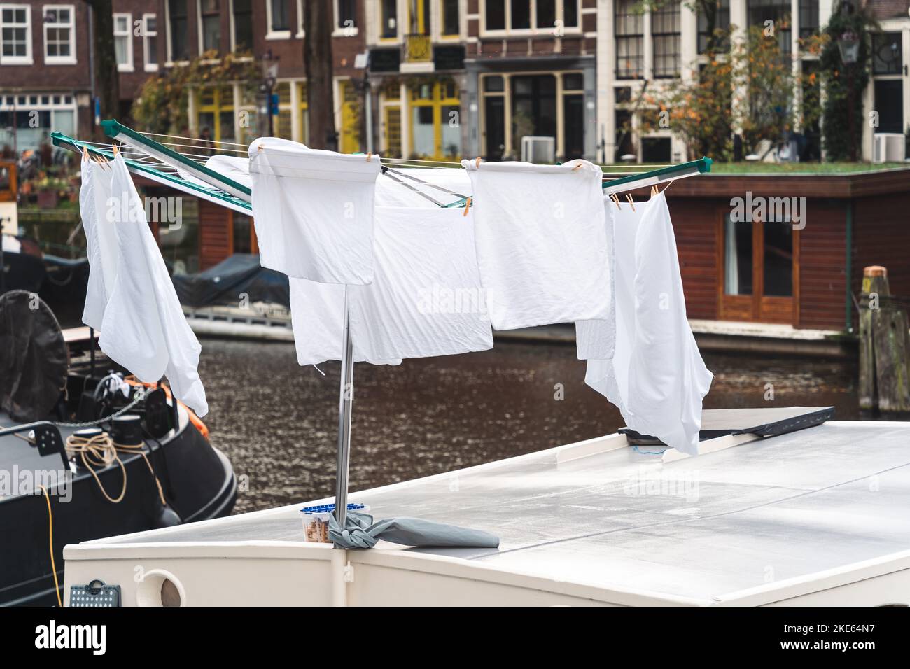 The white clothes hanging on a clothes rack against the buildings in