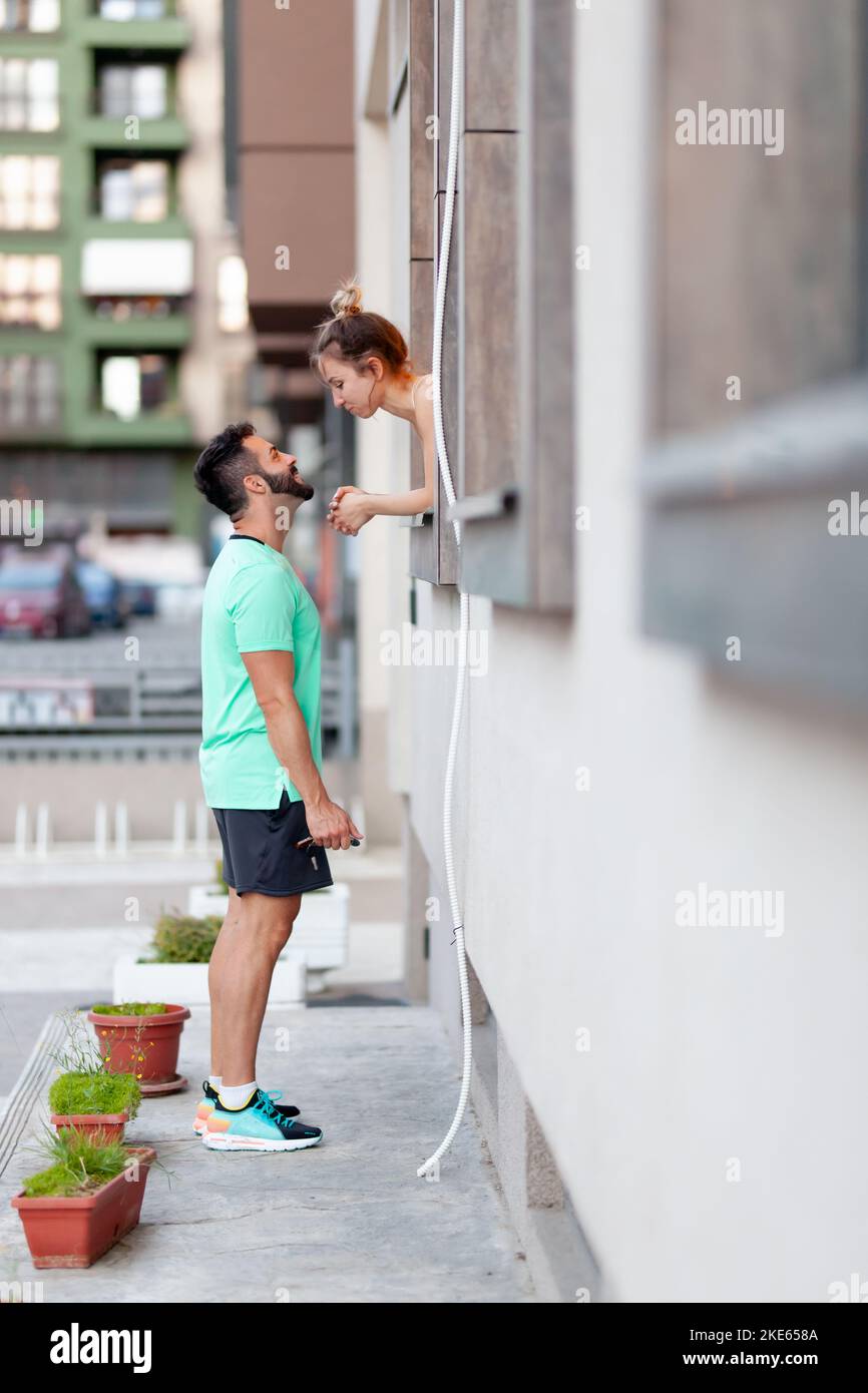 Couple in love. Boy standing outdoors talking with girl from within a