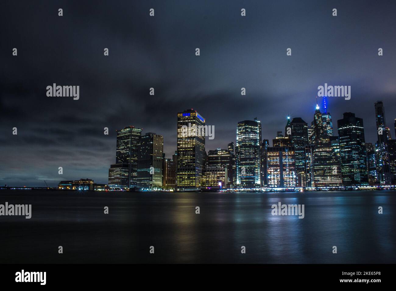 A New York City skyline at cloudy night, with city lights and lights ...