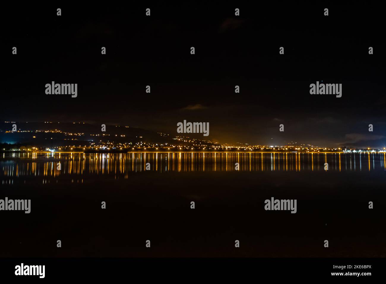 A reflection of city lights at night over a lake Stock Photo - Alamy