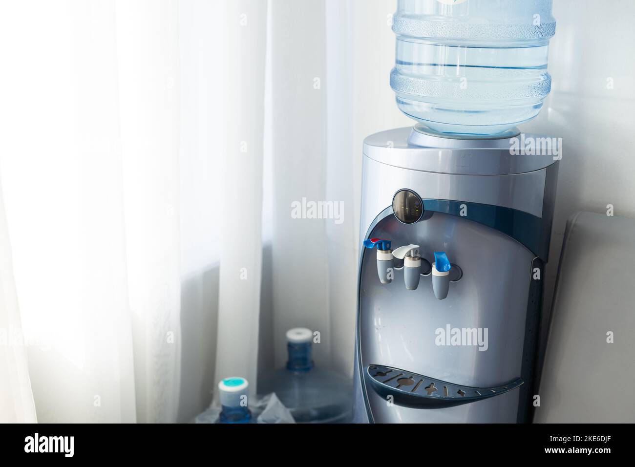 Blue water gallon on water cooler in office Stock Photo Alamy
