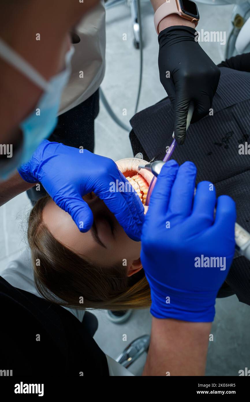 The orthodontist puts metal braces on the patient's teeth. Orthodontic ...