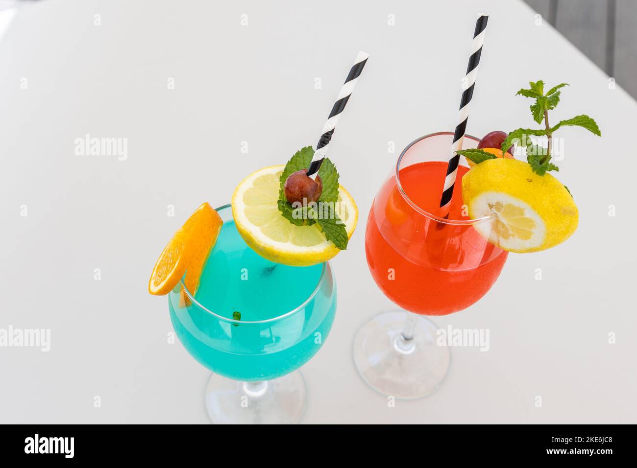 A top view of glasses of Spritz and Blue Hawaii cocktails on white table Stock Photo
