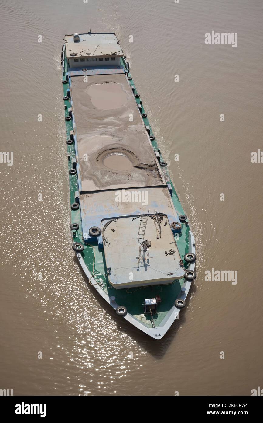 Gravel Cargo Boat along the Tonle Sap River in Phnom Penh Cambodia Stock Photo
