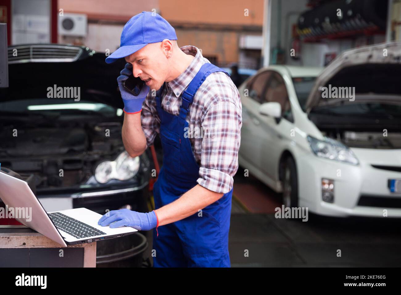 Car mechanic calls on smartphone to client Stock Photo Alamy