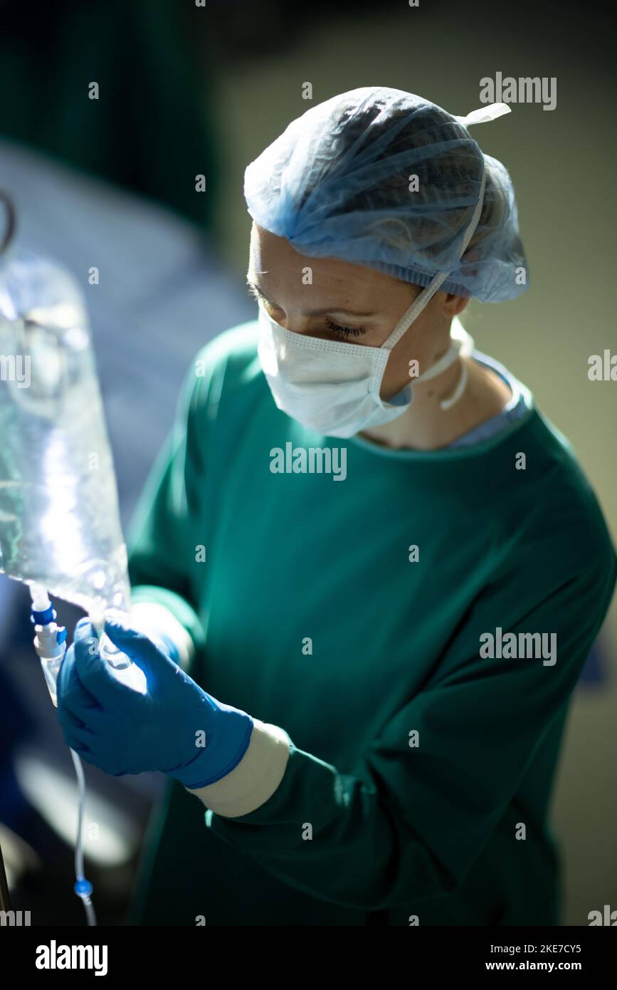 Nurse with IV bag in hospital recovery room with patient Stock Photo - Alamy