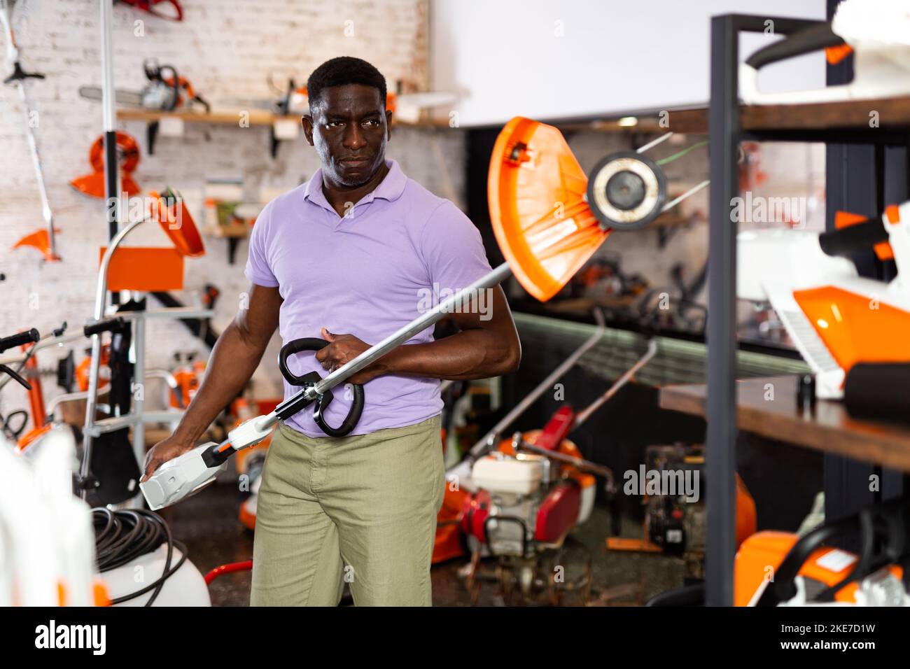 Man choosing strimmer in gardening tools store Stock Photo Alamy