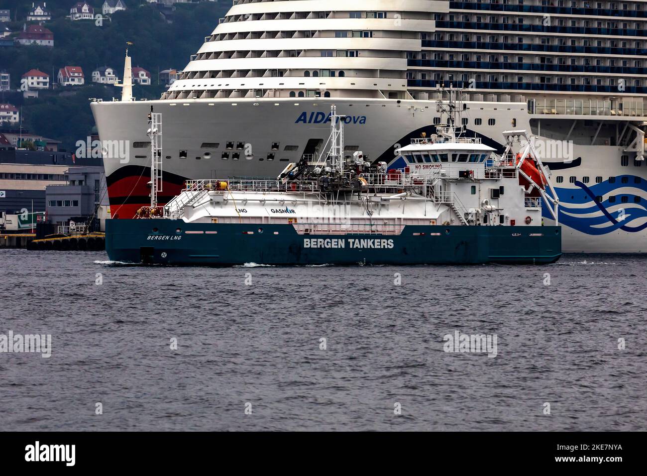 Tanker vessel Bergen LNG at Puddefjorden, in port of Bergen, Norway. Passing in front of cruise ship AIDAnova Stock Photo