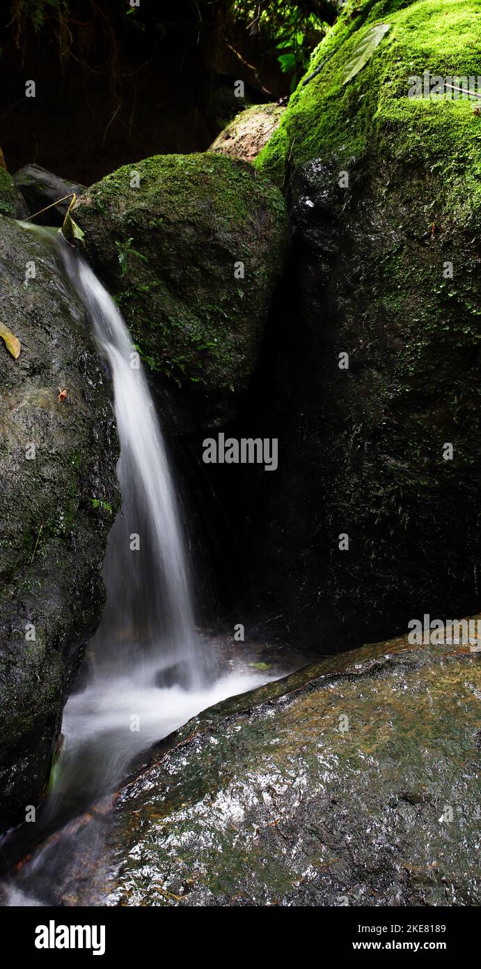 Small Waterfall Between Rocks A vertical shot of a waterfall between the rocks Stock Photo - Alamy