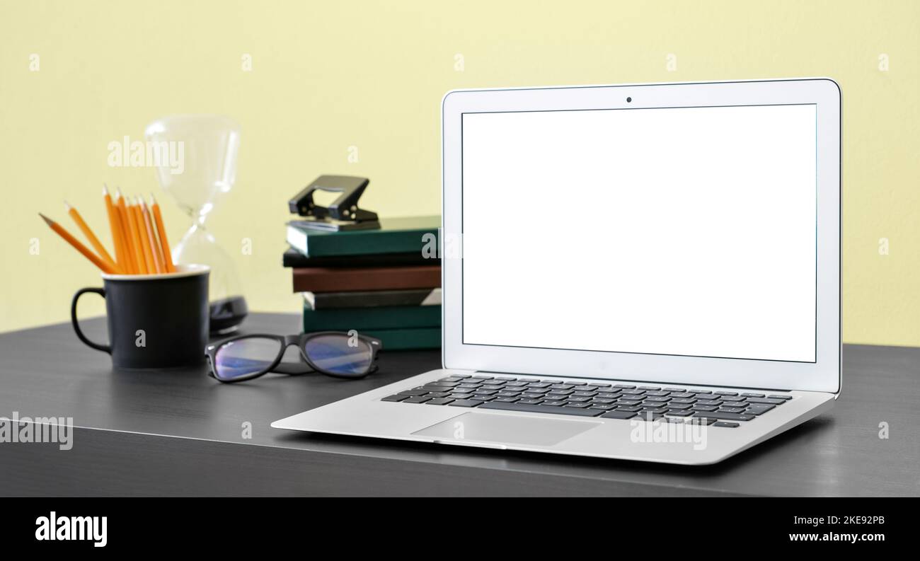 Modern laptop with blank screen on table in office Stock Photo - Alamy