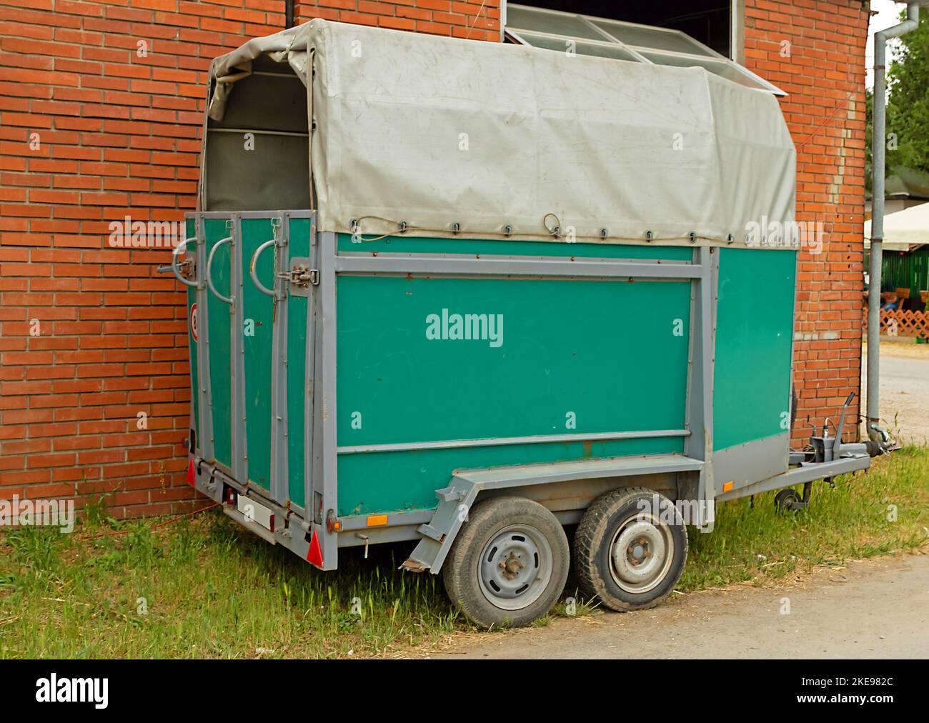 Horse trailer next to red brick wall outside in local fair Stock Photo