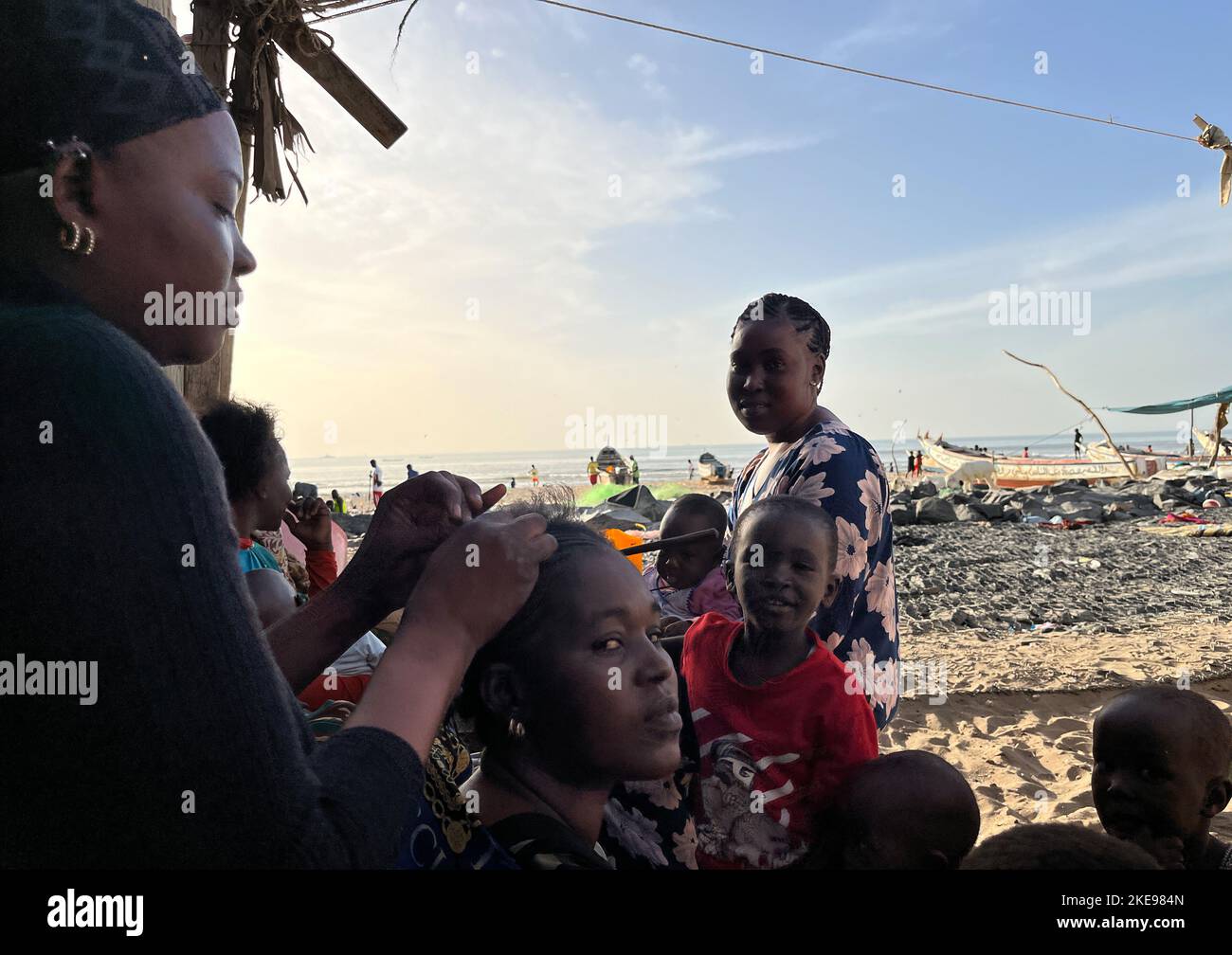St. Louis, Senegal. 01st Nov, 2022. Fama Gueye (l) braids the hair of her family member Marième Dieye (m) on the beach in St. Louis. Credit: Lucia Weiß/dpa/Alamy Live News Stock Photo