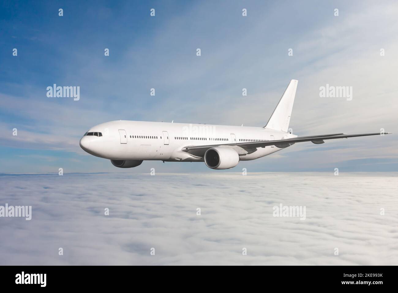 White wide body passenger jet plane fly in the air above the clouds