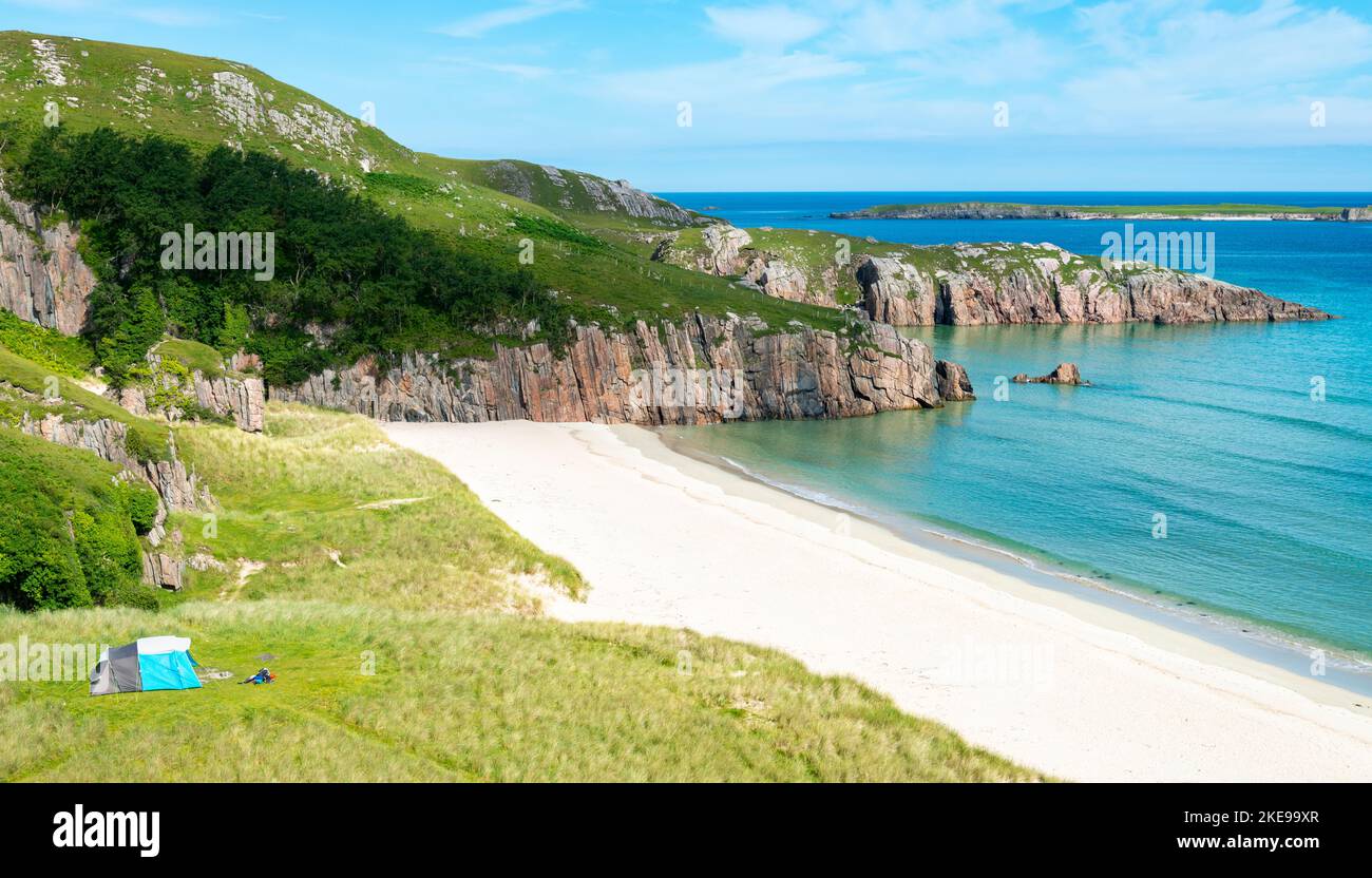 Scottish camping spot,stunning sands,calm Atlantic azure sea,sunny summertime morning,grass covered,underneath Beinn Ceannabeinne mountain,beautiful s Stock Photo
