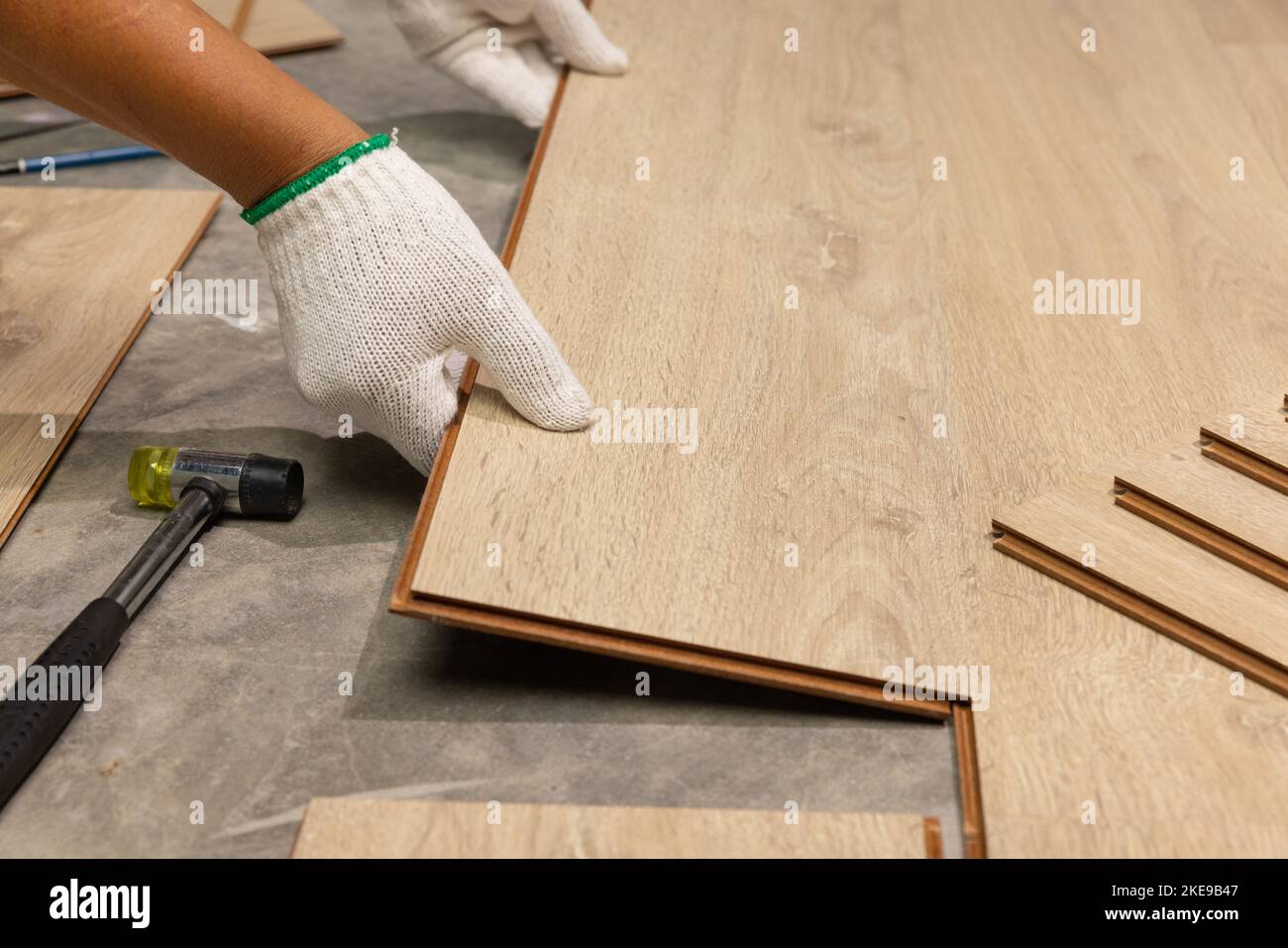 Worker Installing Interlocking laminate floor, home renovation. Stock Photo