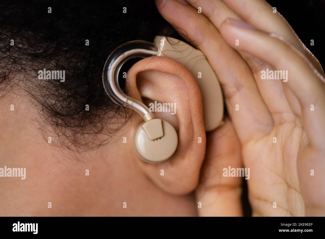 Woman Trying To Hear With Hand Over Ear Stock Photo