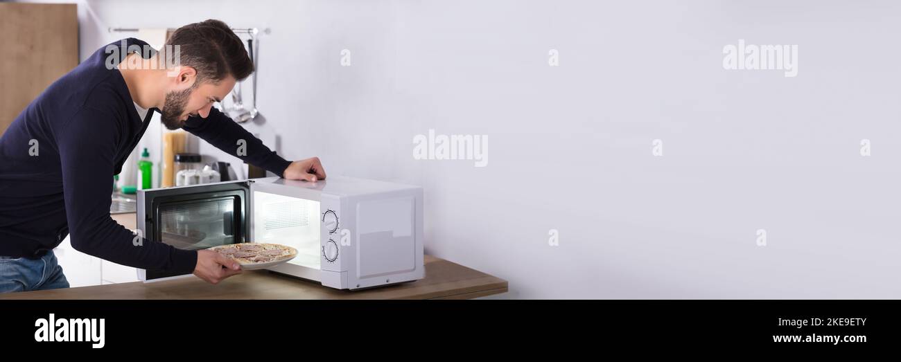 Pizza Dinner Meal In Microwave Oven For Man Stock Photo