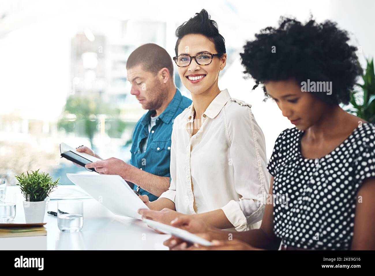 She brings energy into the boardroom. Portrait of a smiling businesswoman sitting in a boardroom with colleagues. Stock Photo